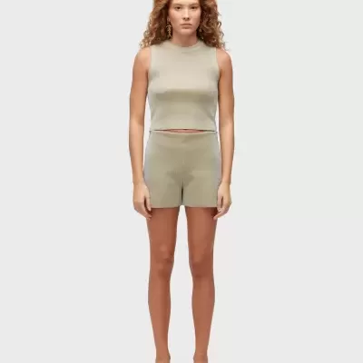 Conjunto feminino bege com top sem mangas e calções, sandálias douradas.