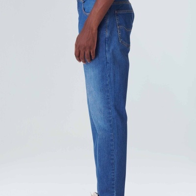 Calças de ganga azuis e sapatilhas brancas com texto 'MADE IN BRAZIL'