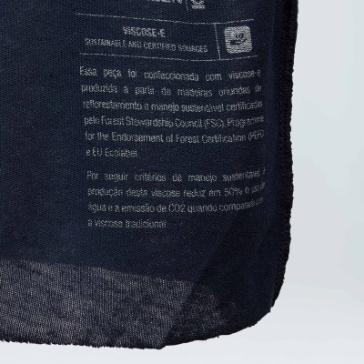 Etiqueta de tecido azul-marinho com texto branco da marca OSKLEN