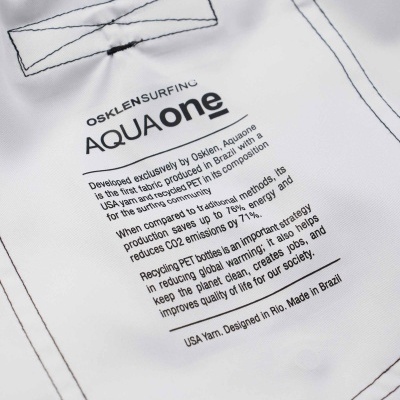 Etiqueta de tecido AQUAone da OSKLEN SURFING com texto informativo sobre sustentabilidade