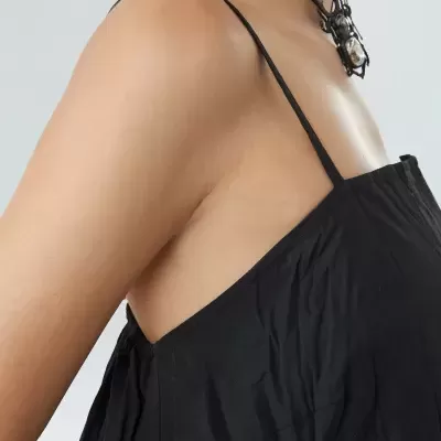 Vestido preto de alças finas e colar com pendente em forma de aranha