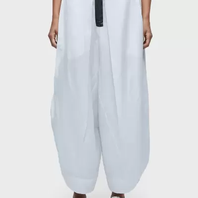 Calças largas brancas com cinto preto e sapatilhas brancas