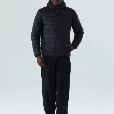 Homem com casaco acolchoado preto com capuz e calças pretas