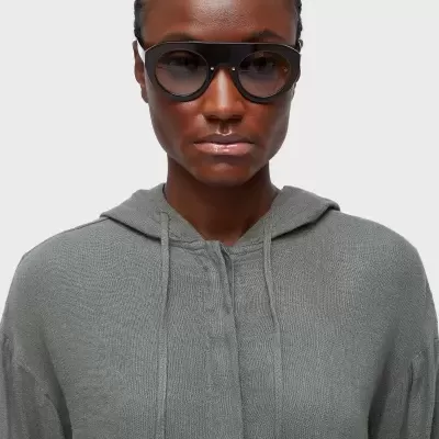 Óculos de sol grandes pretos com lentes escuras e blusão cinza com capuz