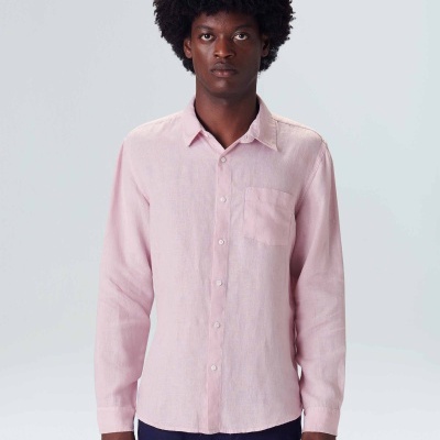 Modelo a usar camisa masculina rosa claro de manga comprida e calças azul escuro