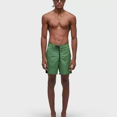 Homem com calções de banho verdes e óculos escuros