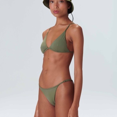 Mulher com biquíni e chapéu verde oliva em fundo cinza claro