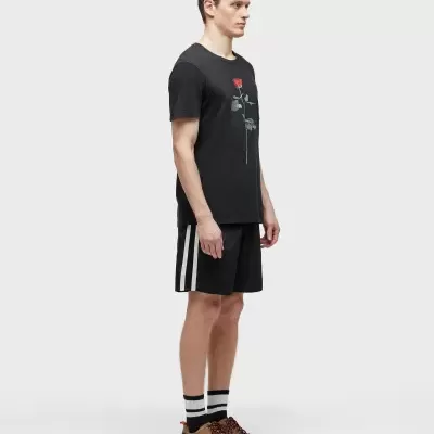 Homem com roupa desportiva preta e sapatos castanhos