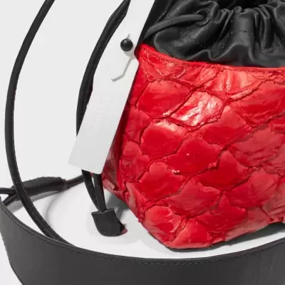 Mala saco vermelha em pele com correia preta larga e etiqueta branca