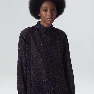 Camisa preta com padrão floral em modelo de manga comprida.