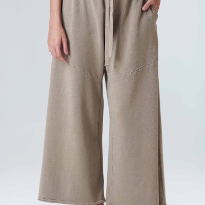 Calças largas bege com cintura elástica e cordão, com sapatilhas brancas