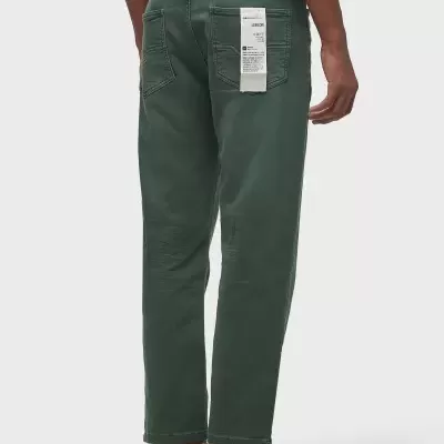 Calças verdes de sarja com etiqueta pendurada no bolso traseiro direito