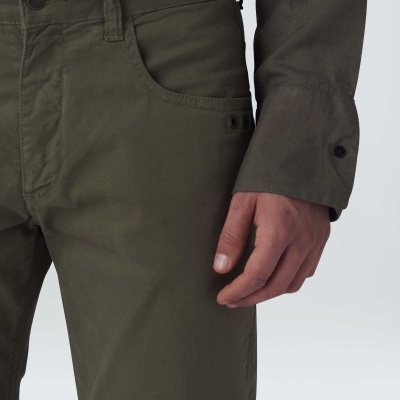 Calças verdes-oliva com camisa de manga comprida do mesmo tom em fundo cinzento