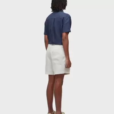 Homem de costas com camisa azul e calções bege