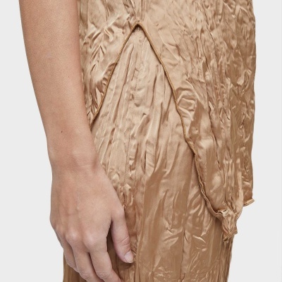 Vestido dourado acetinado com textura vincada e detalhe franzido ligado a braço humano