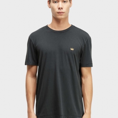Homem com t-shirt preta e calças pretas, em fundo branco.