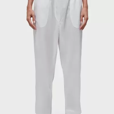 Calças brancas com cintura elástica e bolsos frontais usadas com sandálias pretas