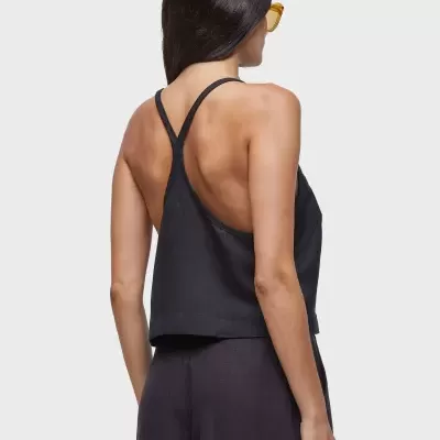 Mulher de costas a usar top preto e calças largas pretas