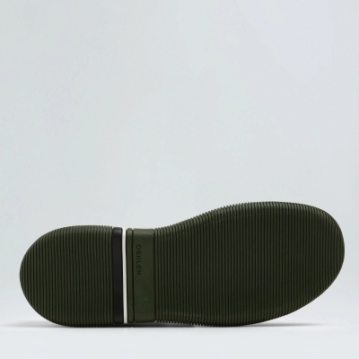 Sola verde escuro de sapato com ranhuras e faixas preta e branca na área do calcanhar