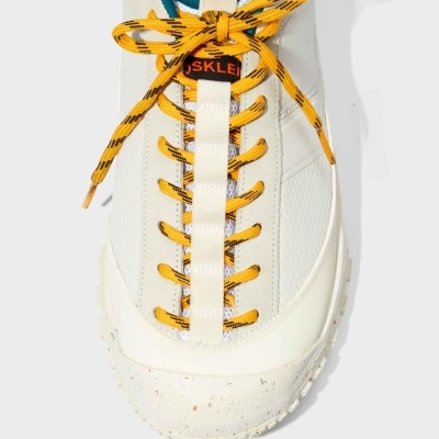 Tênis branco com cadarços amarelos e etiqueta OSKLEI