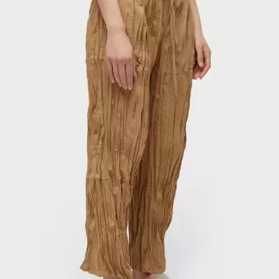 Calças largas castanhas com textura enrugada e cordão à cintura.