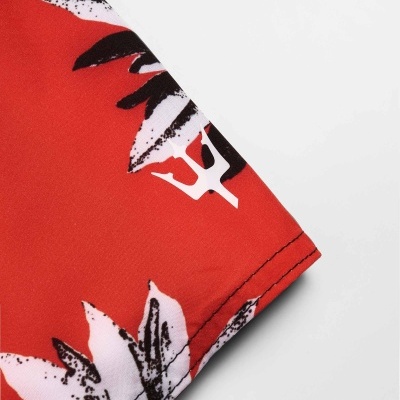 Tecido vermelho com padrão floral preto e branco e costura visível