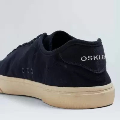 Ténis pretos Osklen com sola bege em fundo branco