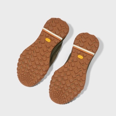 Solas de sapatos castanhas antiderrapantes com faixa e etiqueta Vibram.