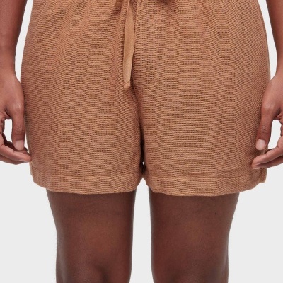 Calções de malha castanho claro com cordão na cintura em modelo masculino