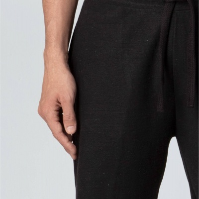 Calções pretos com cordão usados por homem em fundo cinza claro