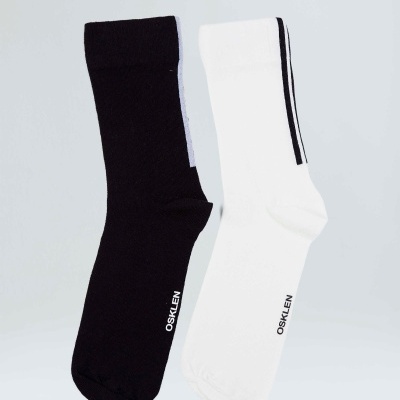 Duas meias compridas, preta e branca, com a palavra OSKLEN e listra preta na branca.