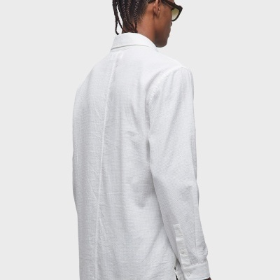 Pessoa de costas com camisa branca texturizada e óculos de sol