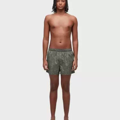 Calções de banho cinza com padrão geométrico em modelo masculino