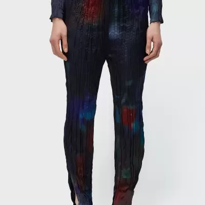 Calças plissadas pretas com manchas coloridas e sandálias pretas