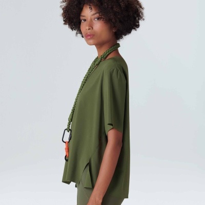 Mulher com conjunto desportivo verde-oliva em fundo branco