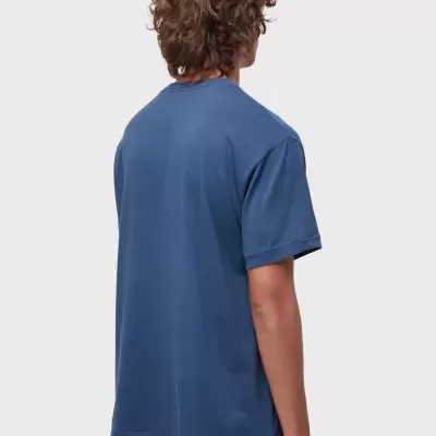 Pessoa de costas com t-shirt azul e calças castanhas