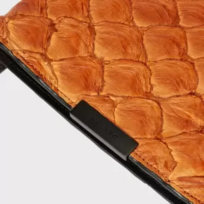 Bolsa ou carteira de pele castanha com textura quadrada em relevo e detalhe metálico preto.