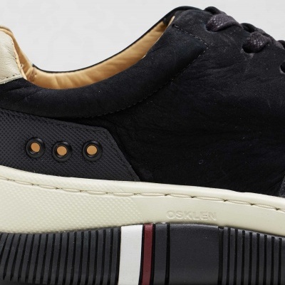 Ténis preto e creme com sola branca com riscas preta, branca e vermelha