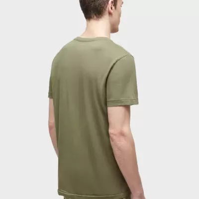 Homem visto de costas usa t-shirt verde-oliva de manga curta e calças bege.