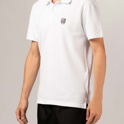 Homem com polo branco e calções pretos em fundo cinzento claro