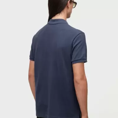 Pessoa de costas com t-shirt polo azul e calças pretas