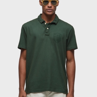 Homem com camisa polo verde escura e óculos de sol amarelos