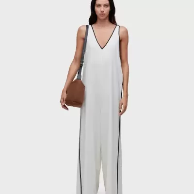 Macacão branco com risca preta e mala castanha