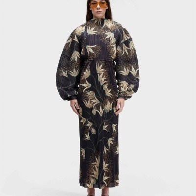 Vestido comprido com padrão floral bege e castanho, mangas largas, sandálias castanhas e óculos laranja