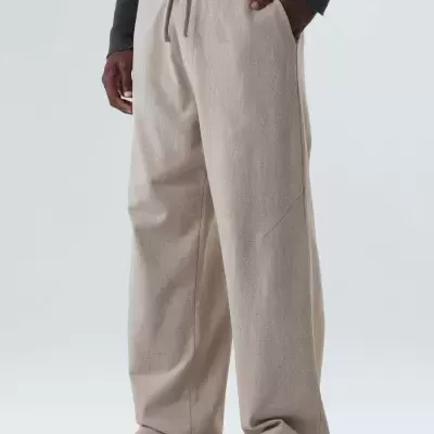 Calças largas bege claras com cordão na cintura em fundo branco