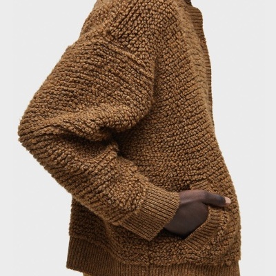 Pulôver castanho de malha espessa com gola alta e bolso lateral, visto de lado