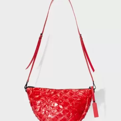 Mala de ombro vermelha com textura de escamas e etiqueta