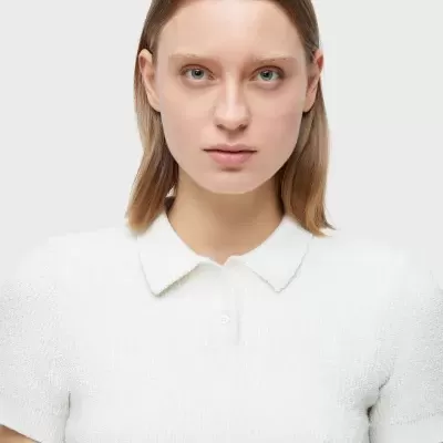 Mulher a usar camisa polo branca de tecido texturizado com gola e botões