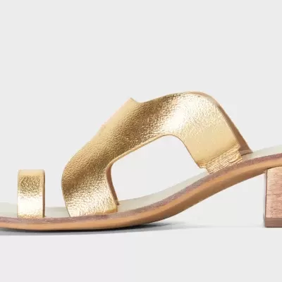 Sandália dourada de salto baixo com sola bege e salto em madeira clara