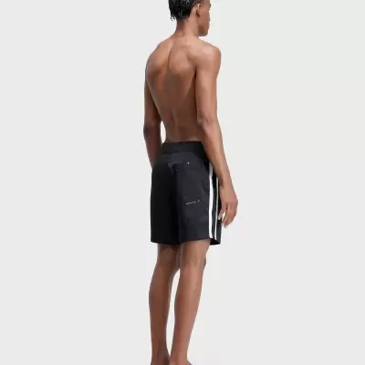 Homem de costas com calções de banho pretos e riscas brancas nas laterais